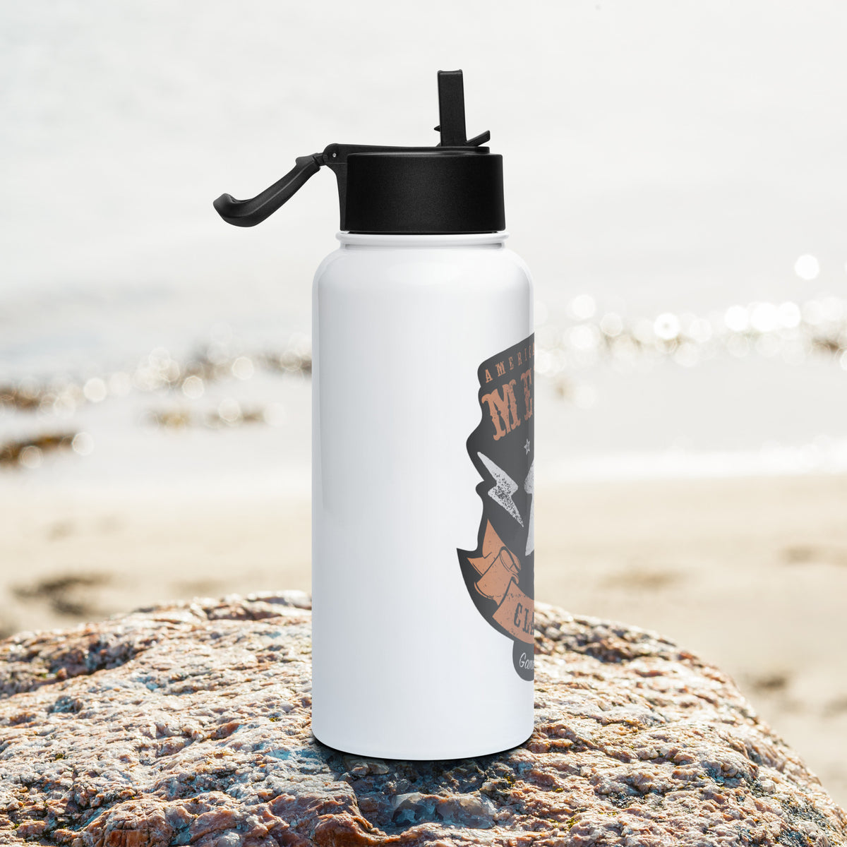 American Meeple Classics design on water bottle positioned on a rock at the beach - Side Shot